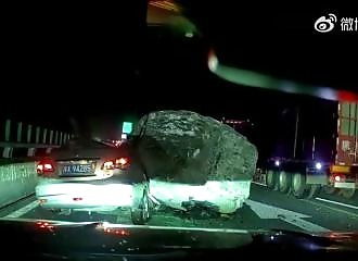 A car is crushed under a huge rock