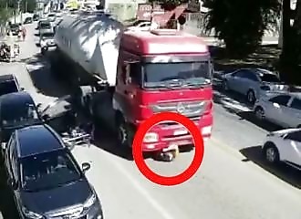  He falls off his motorcycle and goes under a truck! 