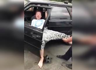 Les policiers ont bien du mal à évacuer ce personnage de son véhicule !