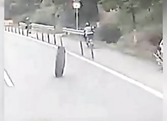 A scooterist stalked by a truck tire!