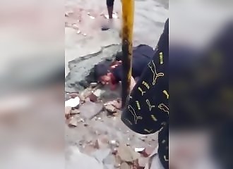 Un vieil homme trébuche et tombe dans un égout à ciel ouvert