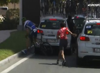 Certainement dernier du peloton, un cycliste se trouve coincé dans la circulation