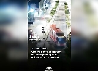 A bus driver continues on his way as a train arrives on his right 