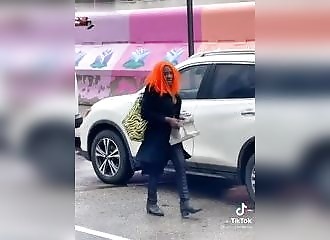 Un homme (ou une femme) avec des cheveux oranges fracasse la vitre d'un taxi pour voler un téléphone