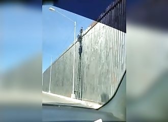 Des migrants mexicains s’amusent sur la barrière de Donald Trump
