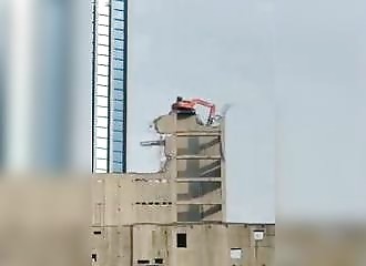Une machine de démolition joue à l'équilibriste au sommet d’un immeuble (Indonésie)
