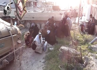 Des militaires irakiens aident des civils à se réfugier lors des combats avec l’EI