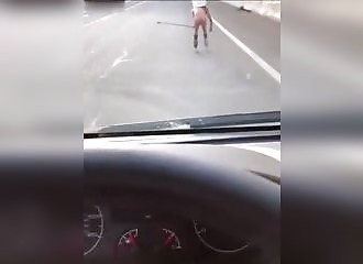 Totalement à poil, un homme fait du roller sur une voie rapide