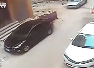 Un homme tente de casser la vitre d’une voiture avec une grosse pierre