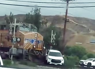 A heroic policeman pulls a child from a car stuck on the tracks, just as a train is approaching