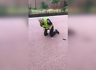 A policeman falls to the ground while tobogganing